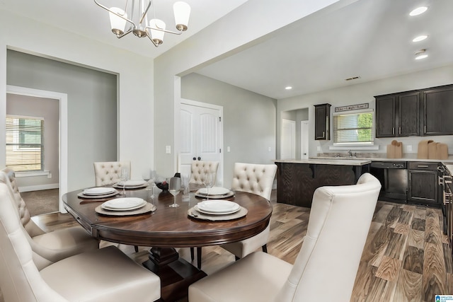 dining room with a healthy amount of sunlight, dark wood-type flooring, and a chandelier