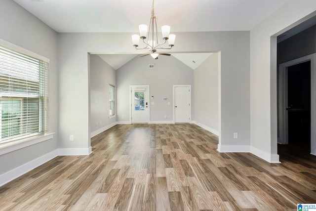 interior space with hardwood / wood-style flooring, an inviting chandelier, plenty of natural light, and lofted ceiling