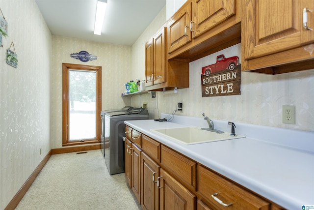 laundry room with cabinets, sink, and washer and dryer