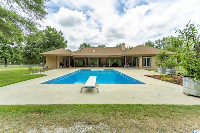 view of pool with a yard, a patio, and a diving board