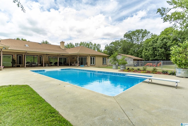 view of swimming pool with a patio and a diving board