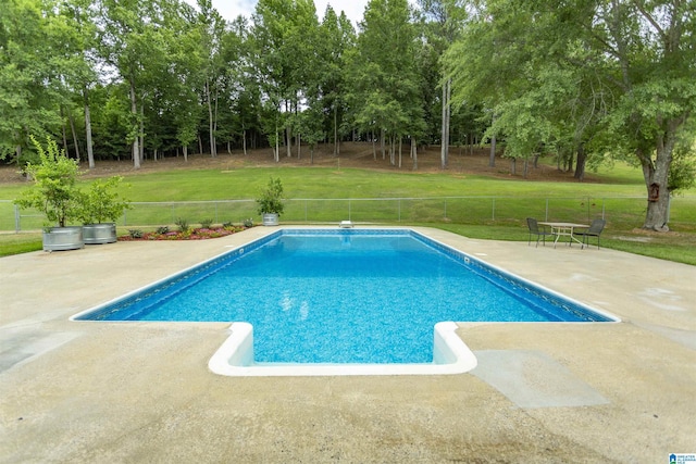 view of swimming pool featuring a lawn and a patio