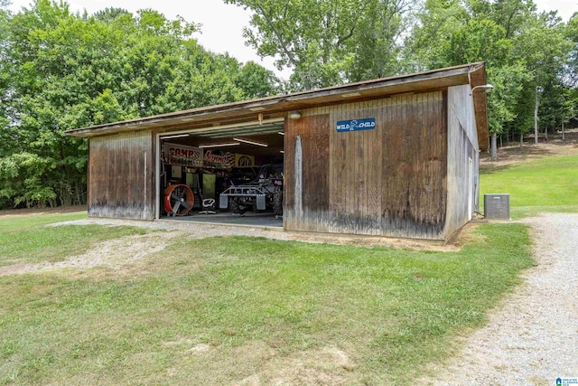 view of outbuilding with a lawn and central air condition unit