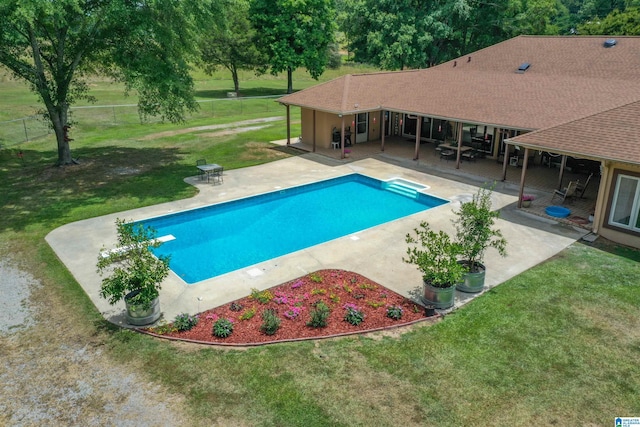 view of swimming pool featuring a yard, a patio, and a diving board