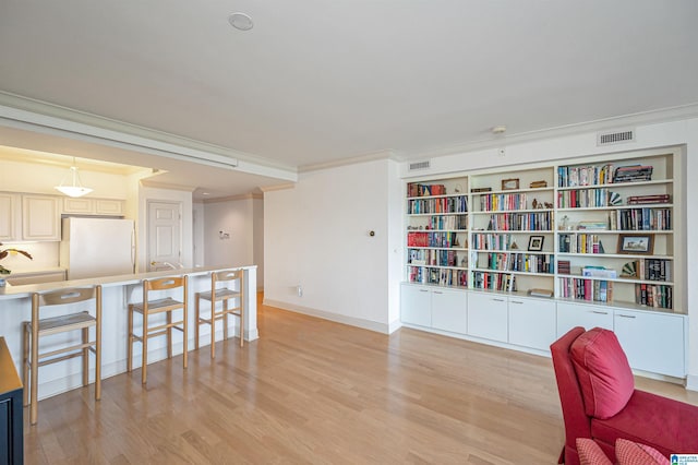 interior space with visible vents, light wood-style floors, and ornamental molding