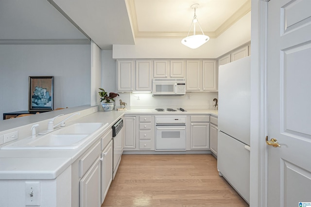 kitchen with crown molding, a peninsula, light wood-style floors, white appliances, and a sink