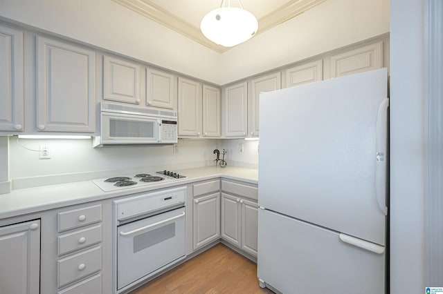 kitchen with white appliances, light countertops, light wood-style floors, and crown molding