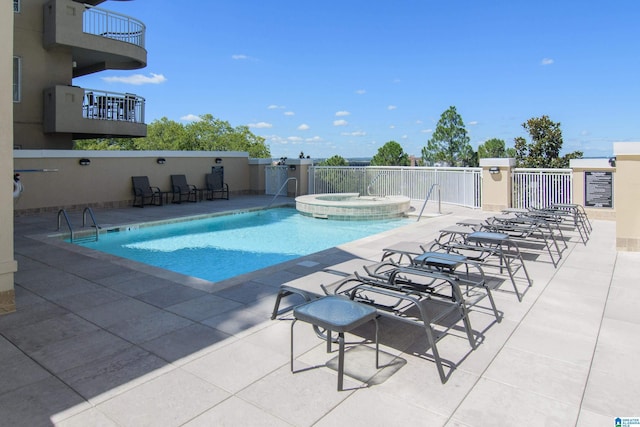 pool with a patio area and a community hot tub