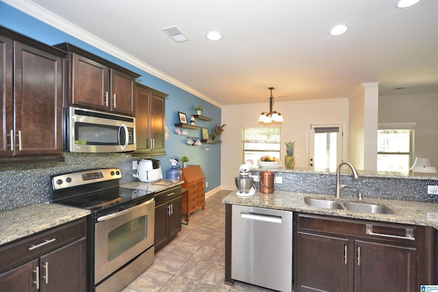 kitchen with tasteful backsplash, sink, hanging light fixtures, stainless steel appliances, and dark brown cabinets