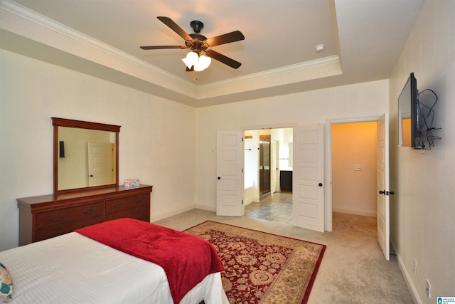 carpeted bedroom featuring a tray ceiling, ornamental molding, and ceiling fan