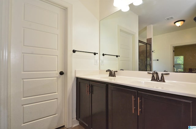 bathroom with vanity and a shower with door