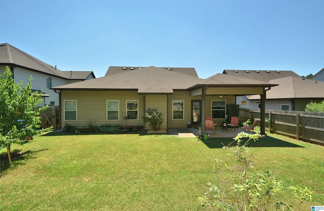 back of property with a yard and a patio area