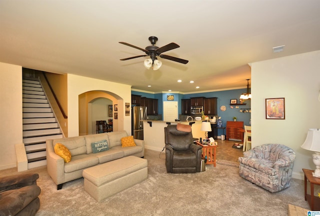 carpeted living room with ornamental molding and ceiling fan with notable chandelier