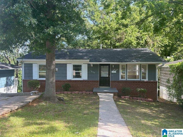 view of front of home featuring brick siding and a front lawn