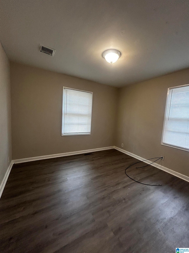 unfurnished room with dark hardwood / wood-style flooring