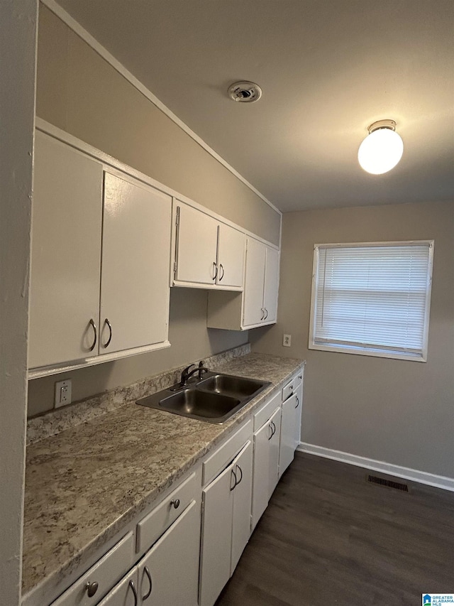 1616 Hatchet Ave, Tarrant, AL 35217 - kitchen with baseboards, visible vents, dark wood-style flooring, a sink, and white cabinets