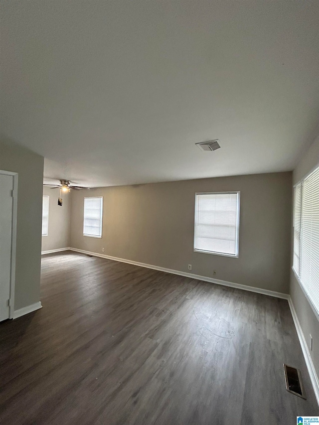 empty room featuring dark wood-type flooring and ceiling fan