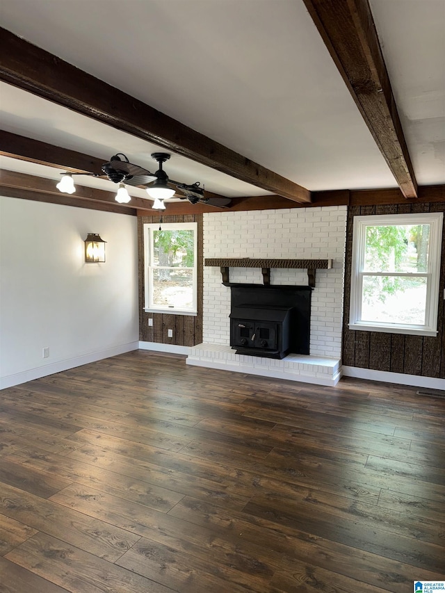 unfurnished living room featuring ceiling fan, beam ceiling, and dark wood-type flooring