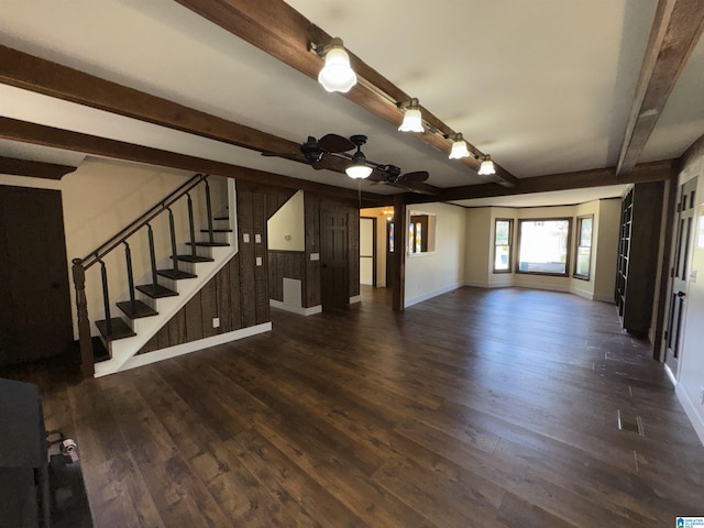 unfurnished living room featuring ceiling fan, beam ceiling, and dark wood-type flooring