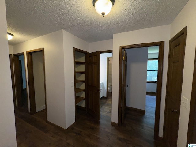 hallway featuring a textured ceiling and dark hardwood / wood-style flooring