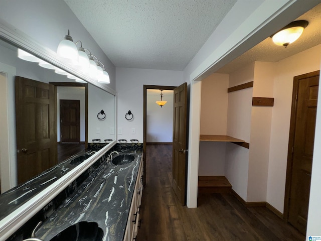 bathroom with vanity, wood-type flooring, and a textured ceiling