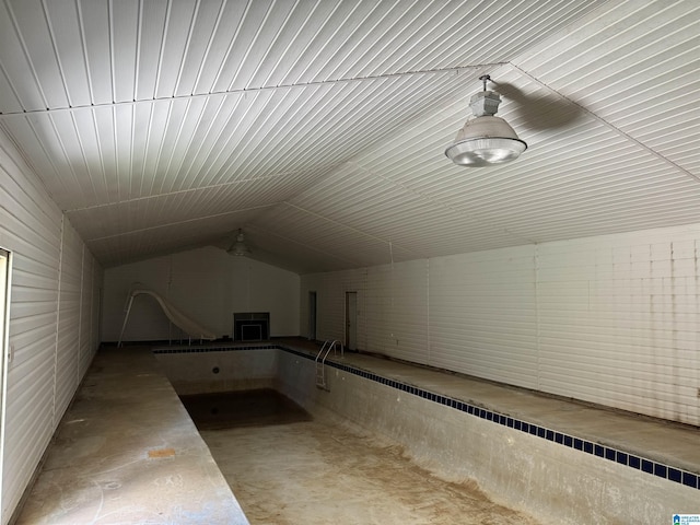 additional living space featuring concrete floors and vaulted ceiling