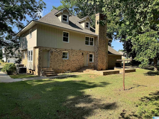 back of property with a lawn and central AC