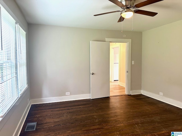 empty room with dark hardwood / wood-style flooring and ceiling fan