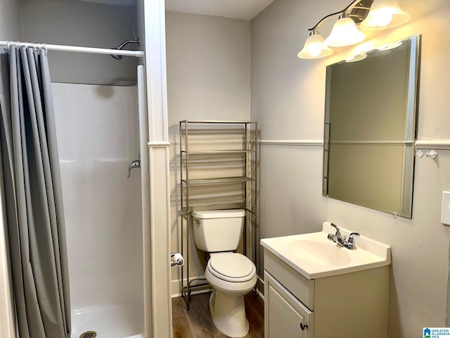 bathroom with hardwood / wood-style flooring, vanity, a shower with curtain, and toilet