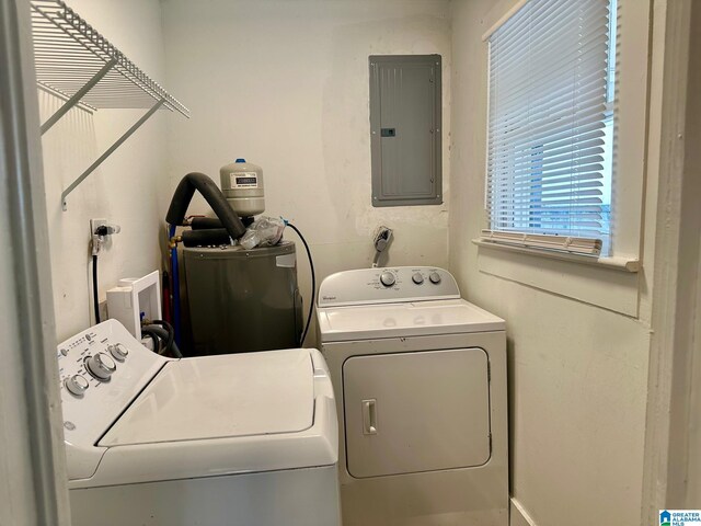 clothes washing area with electric water heater, electric panel, and washer and dryer