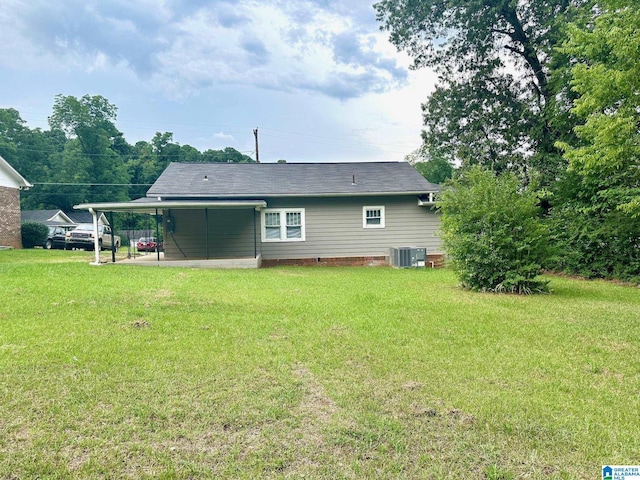 rear view of property with central AC unit, a lawn, and a carport