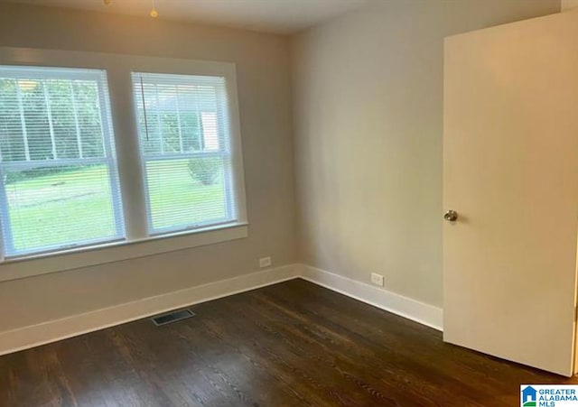 unfurnished room with dark hardwood / wood-style flooring and a wealth of natural light