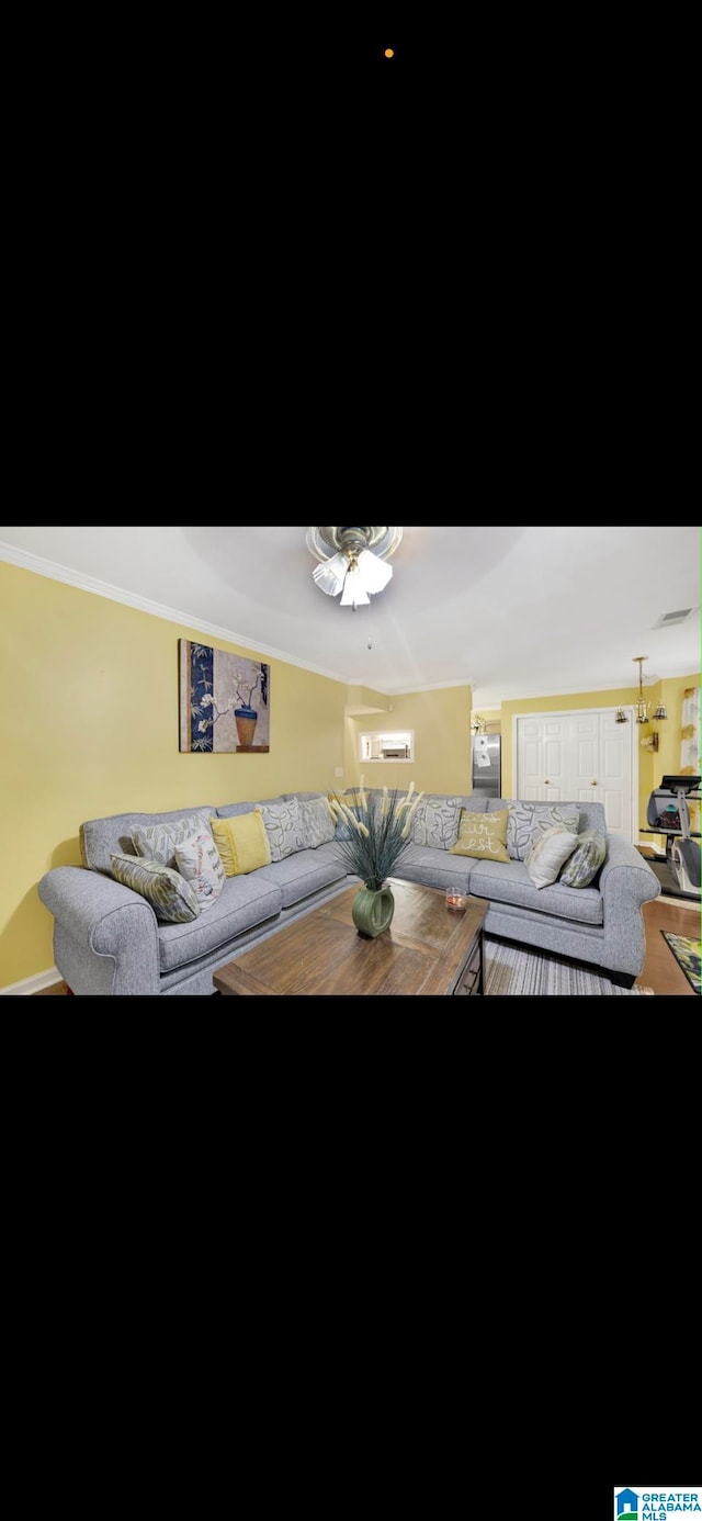 living room featuring ceiling fan, ornamental molding, and wood-type flooring