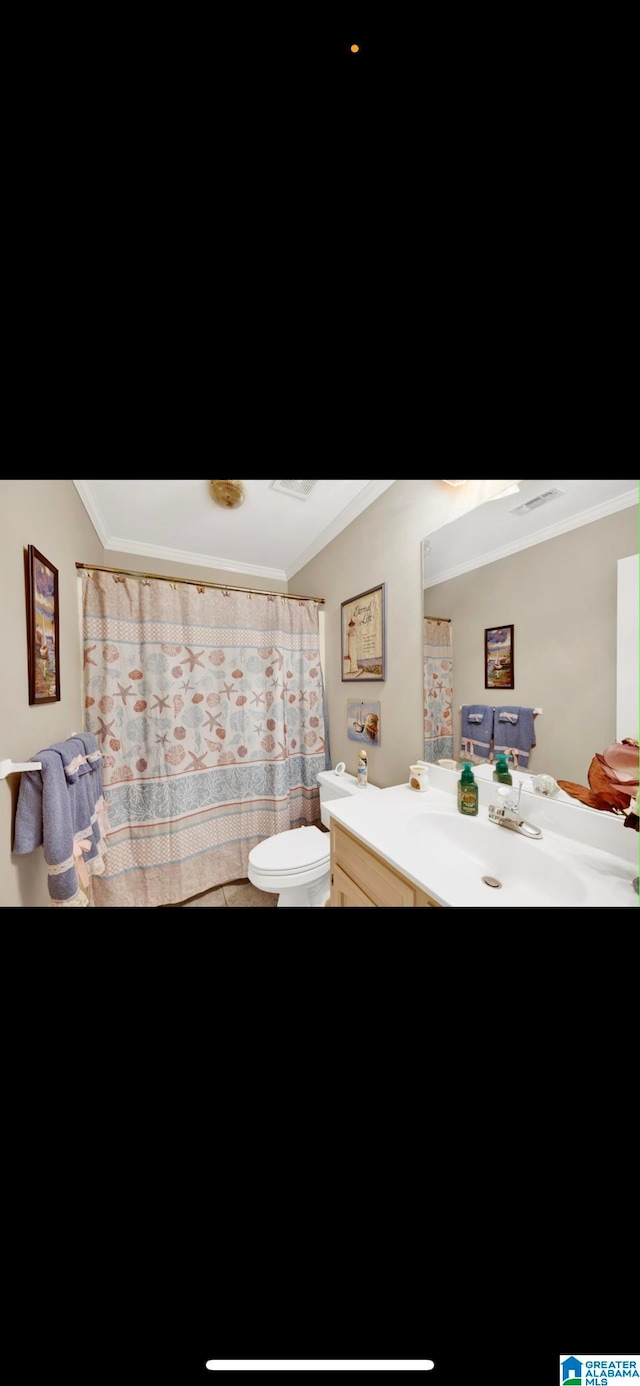 bathroom with tile flooring, ornamental molding, toilet, and vanity