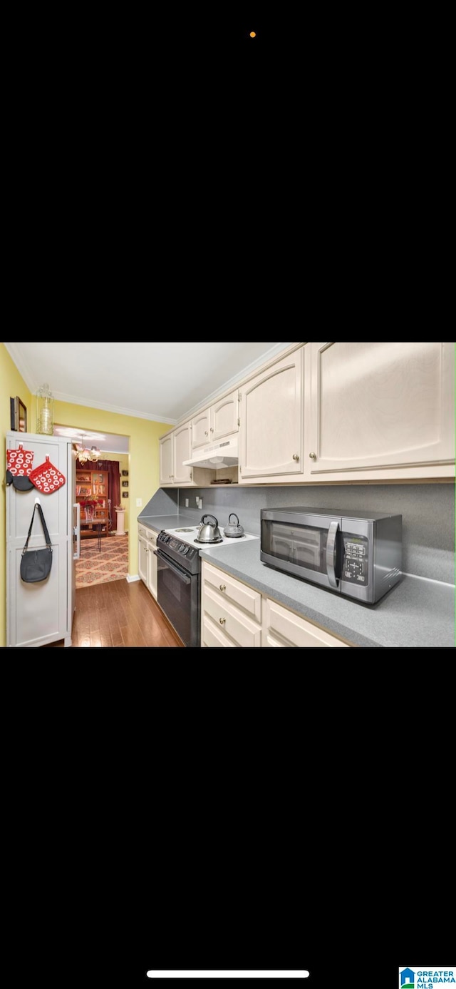 kitchen featuring white refrigerator, white cabinets, black electric range, and dark wood-type flooring