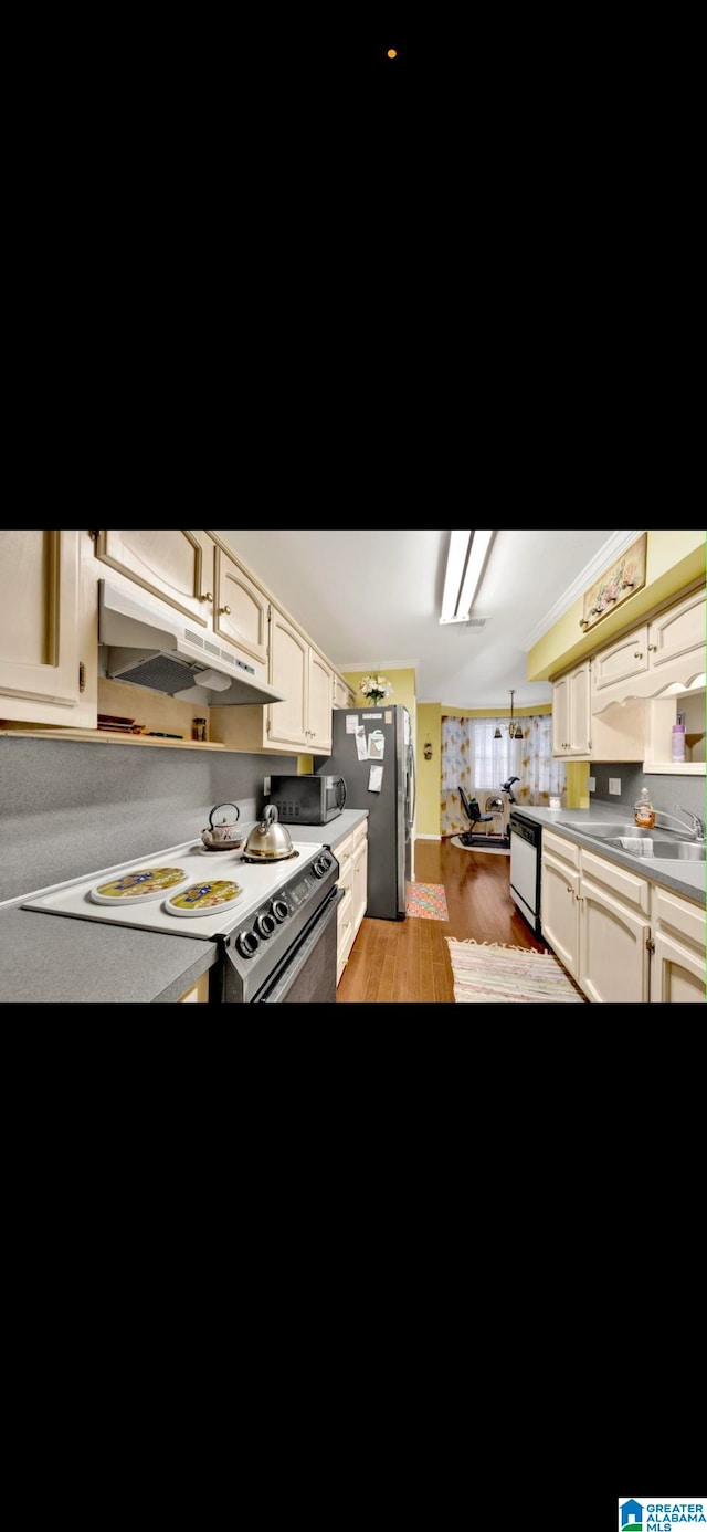 kitchen featuring light hardwood / wood-style flooring, cream cabinets, and appliances with stainless steel finishes