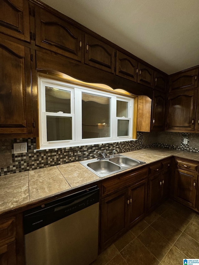 kitchen featuring dishwasher, dark brown cabinets, backsplash, and sink