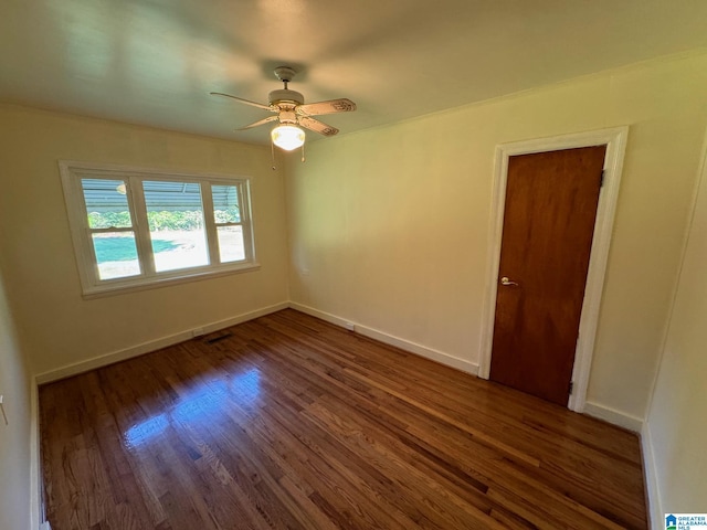 spare room featuring ceiling fan and dark hardwood / wood-style floors