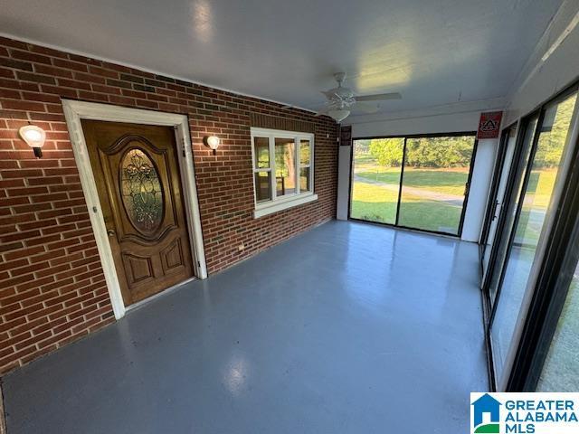 unfurnished sunroom with ceiling fan