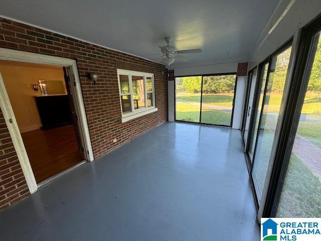 unfurnished sunroom with ceiling fan