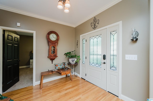 entryway with ornamental molding, wood-type flooring, and an inviting chandelier