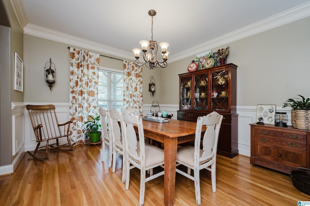 dining room featuring ornamental molding, a chandelier, and light hardwood / wood-style floors