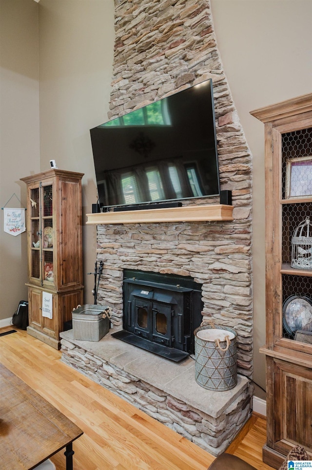 room details with hardwood / wood-style floors and a wood stove