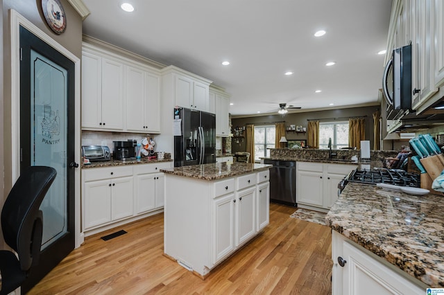 kitchen featuring light hardwood / wood-style floors, black appliances, dark stone counters, and white cabinets