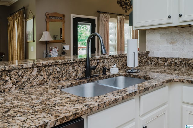 kitchen with white cabinetry, sink, tasteful backsplash, and stone countertops