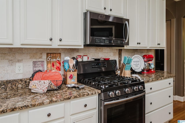 kitchen with stone counters, appliances with stainless steel finishes, hardwood / wood-style floors, white cabinetry, and decorative backsplash