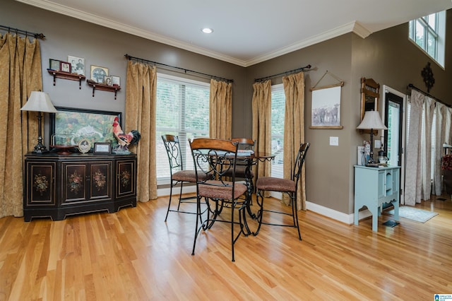 dining room with ornamental molding and light hardwood / wood-style floors