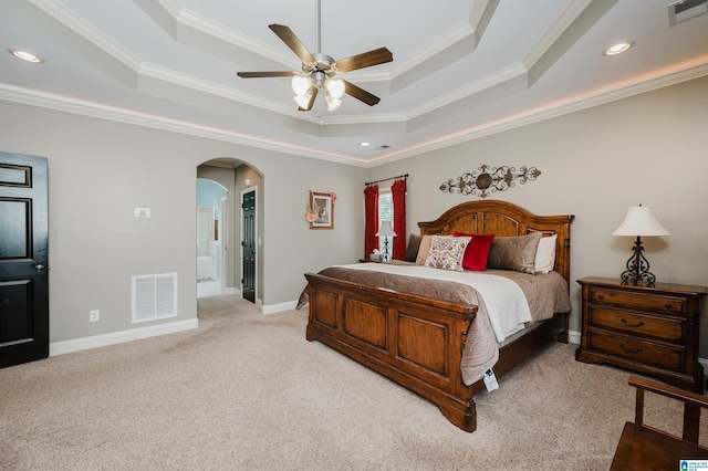 bedroom featuring crown molding, a tray ceiling, light colored carpet, and ceiling fan