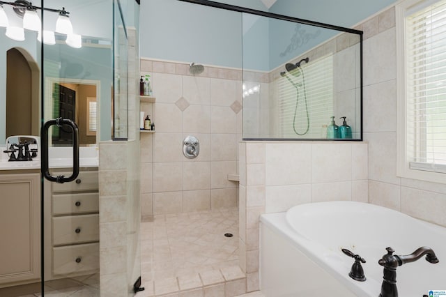 bathroom with independent shower and bath, sink, and tile walls