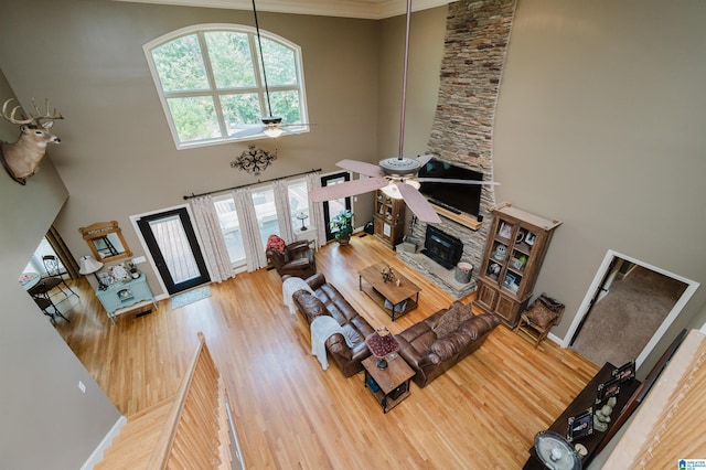 living room with a wealth of natural light, ceiling fan, and a high ceiling